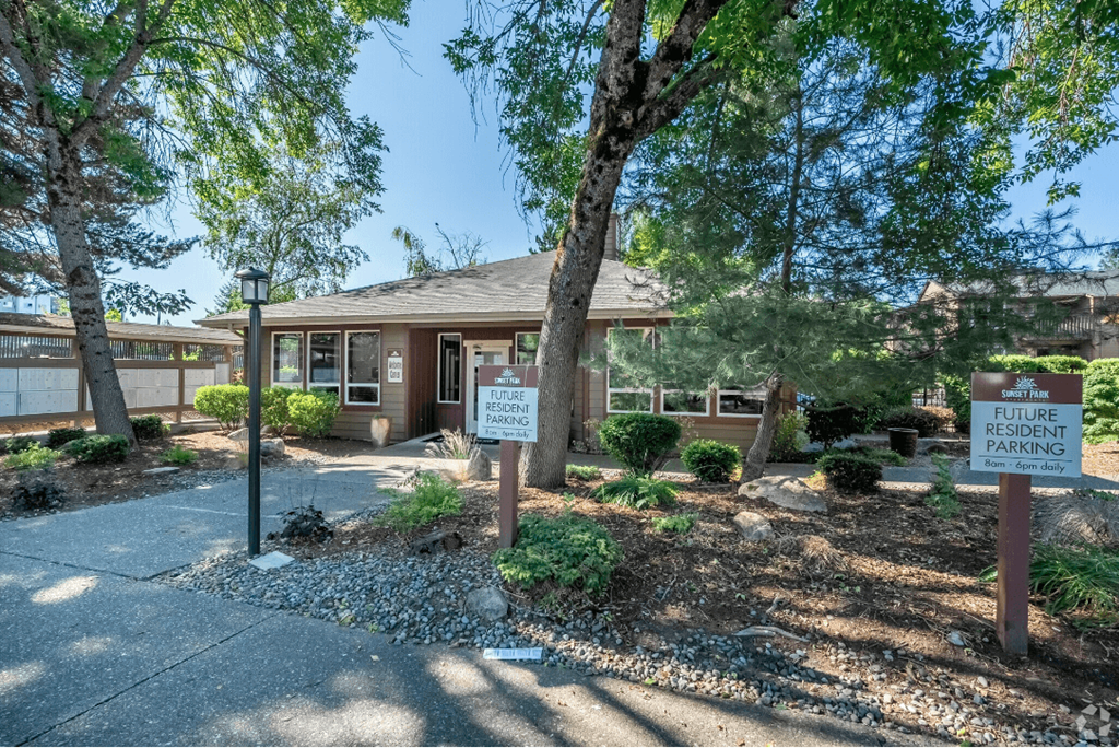 a building with a sign in front of it and trees at Sunset Park Apartments, Seattle, WA, Washington , 98146