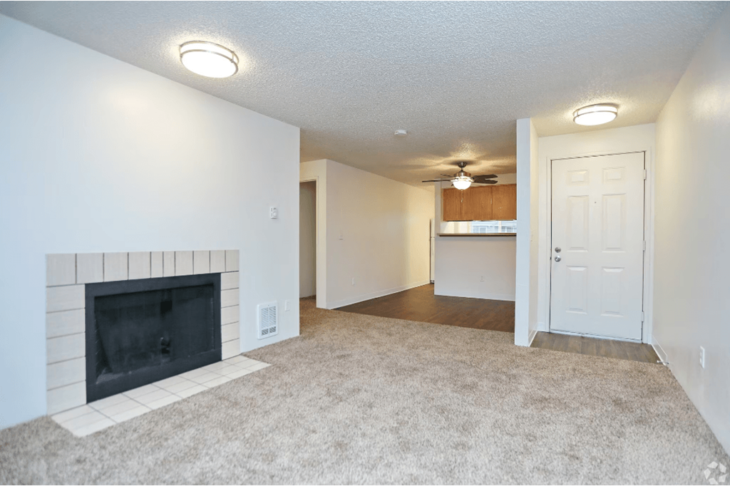 Living room with a fireplace and a kitchen at Sunset Park Apartments, Seattle