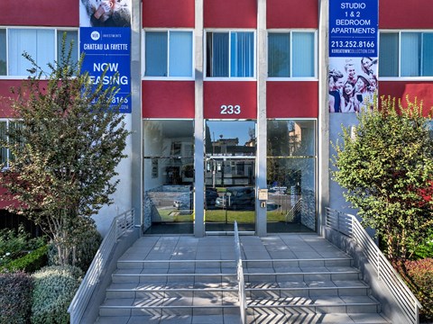 The front of a building with a red awning and a sign that says "Studio 1 & 2 Bedroom Apartments".