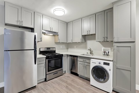 A modern kitchen with a stainless steel refrigerator and a white dishwasher.