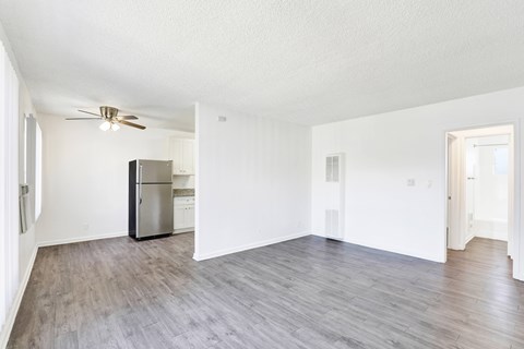 A spacious room with a refrigerator and a ceiling fan at Sylvan Gardens,Van Nuys,California