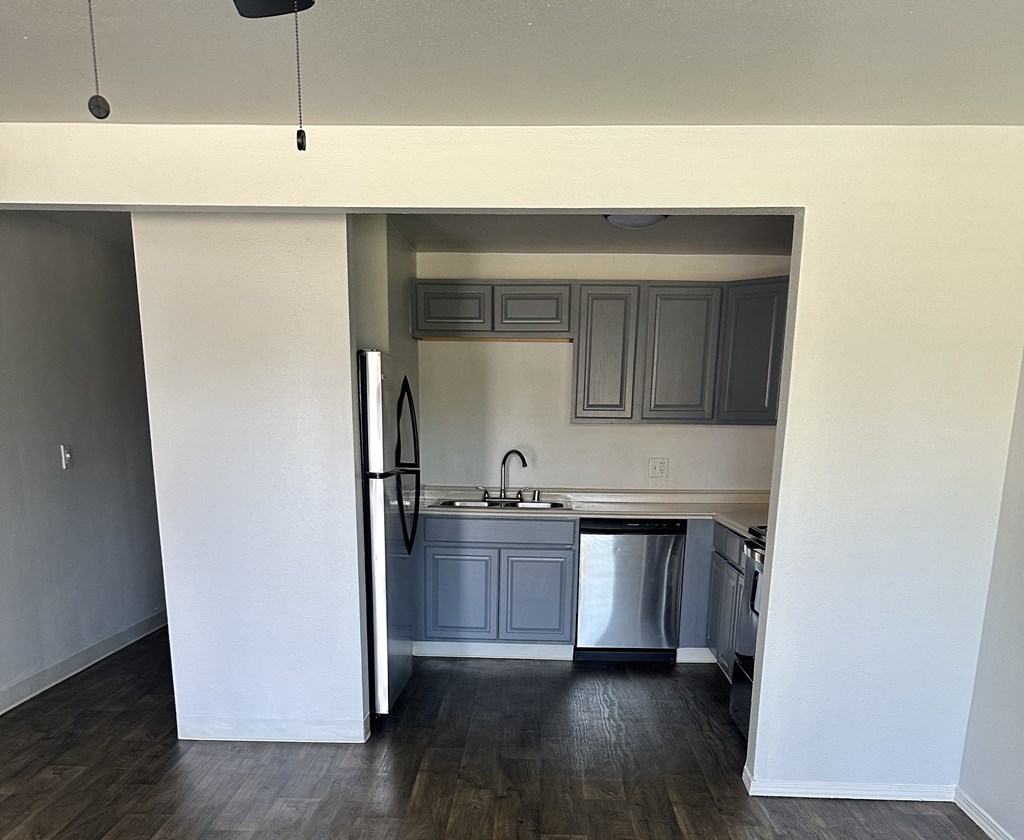 A kitchen with a refrigerator, sink, and dishwasher.