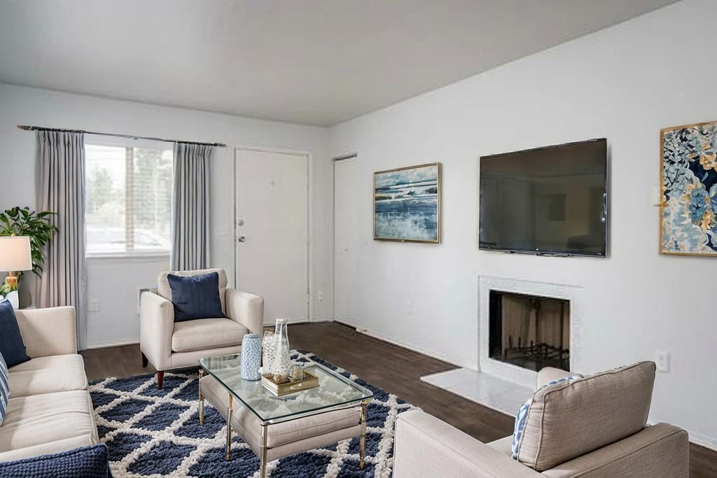A living room with a fireplace, two chairs, and a coffee table.