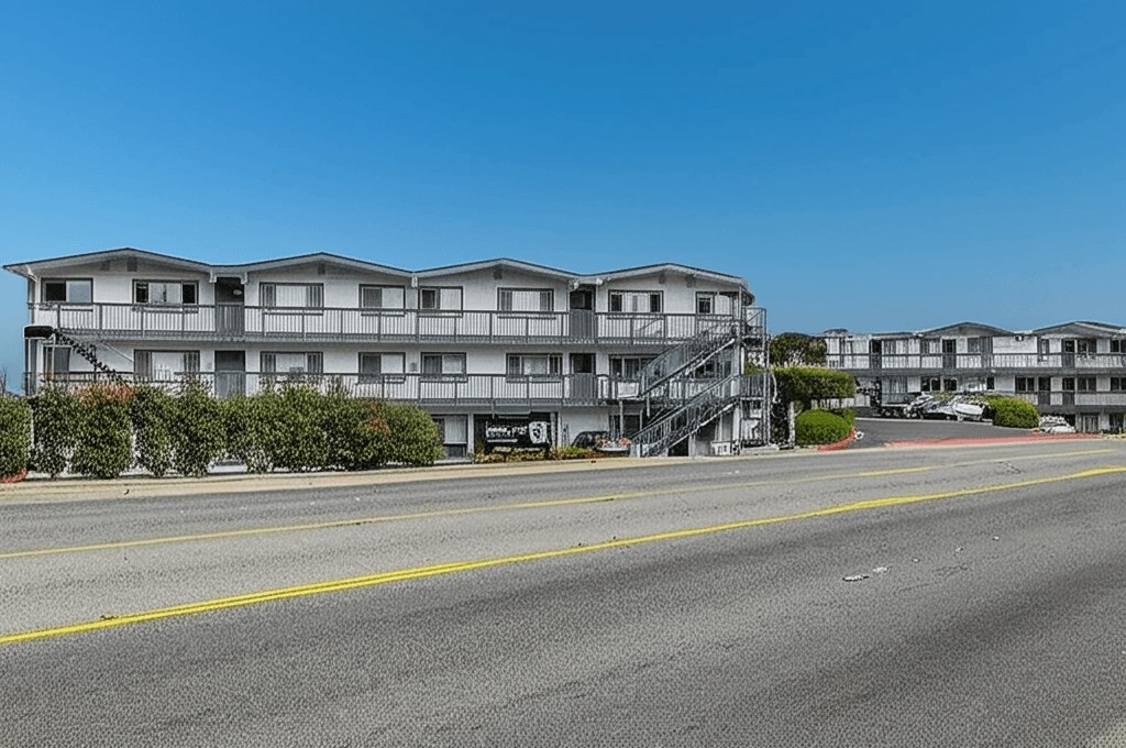 A multi-story building with a parking lot in front.