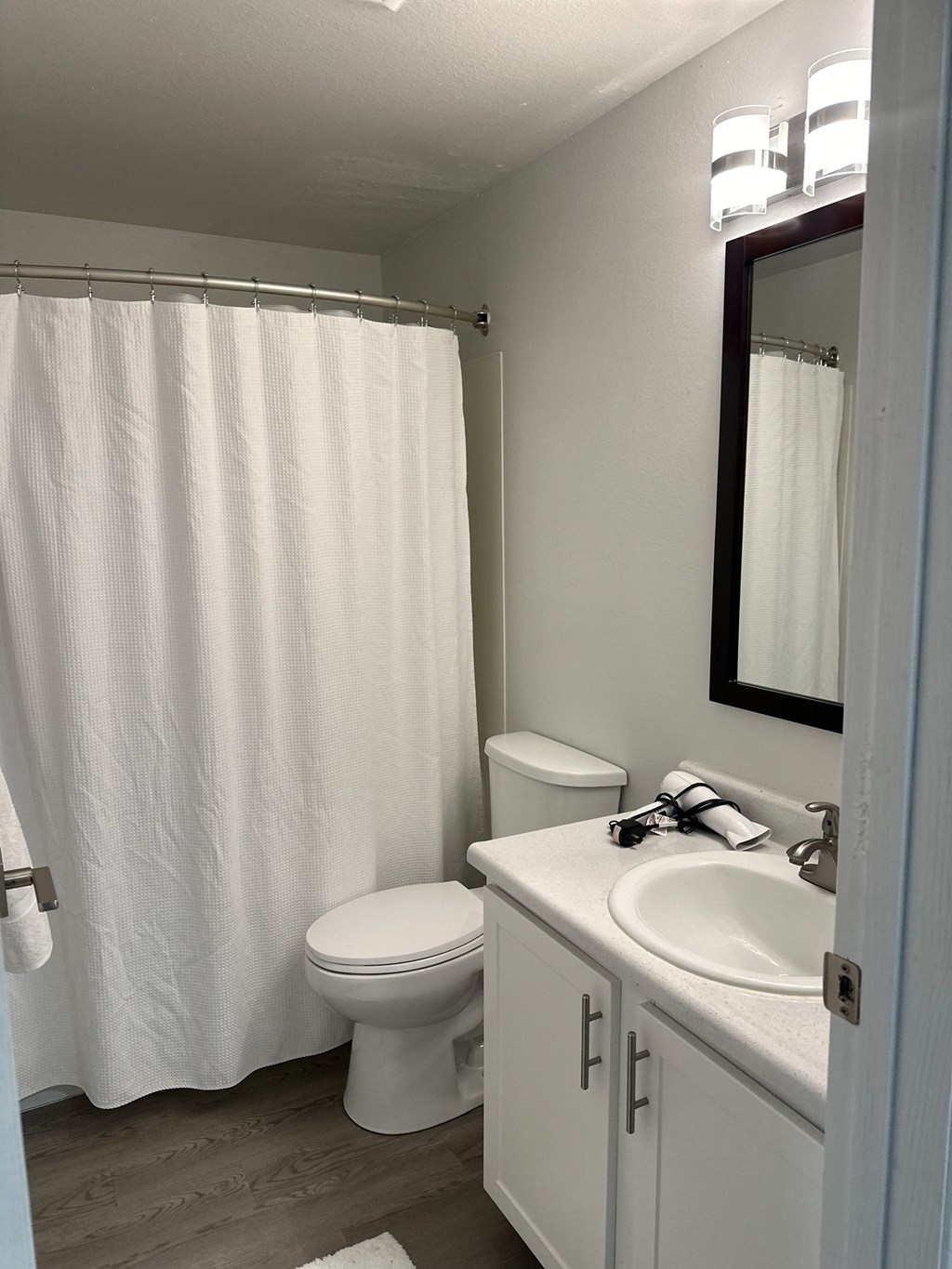 A white toilet sits next to a white sink in a bathroom.