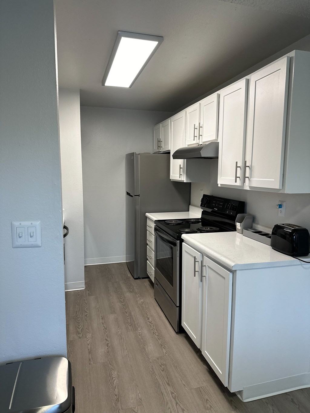 A kitchen with white cabinets and a black stove top oven.