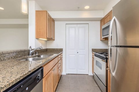 a kitchen with granite counter tops and stainless steel appliances at Delano, Redmond