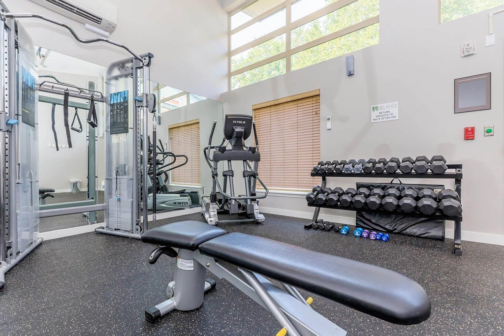 a gym with weights and a mirror and a window at Delano, Washington