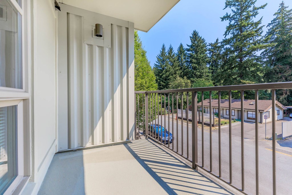 a balcony with a view of a parking lot and trees  at Delano, Redmond