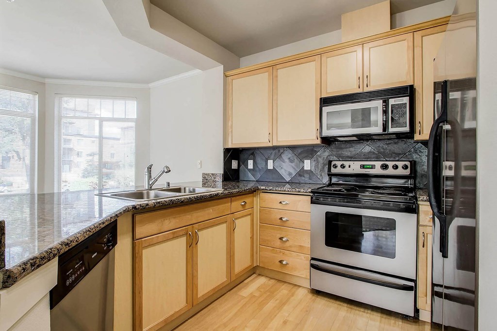 a kitchen with stainless steel appliances and wooden cabinets  at Delano, Redmond Washington