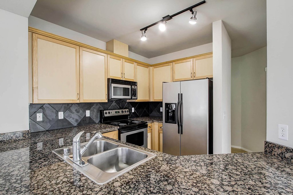 a kitchen with granite counter tops and a stainless steel refrigerator  at Delano, Redmond, WA 98052