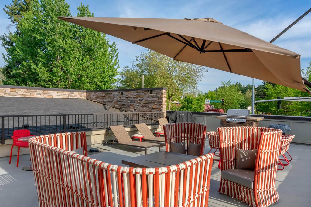 a patio with tables and chairs and an umbrella  at Delano, Redmond, WA 98052