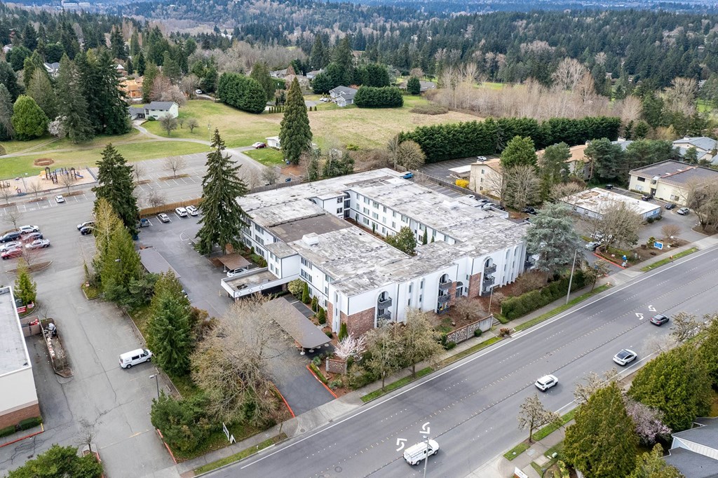 an aerial view of a building with trees and a street