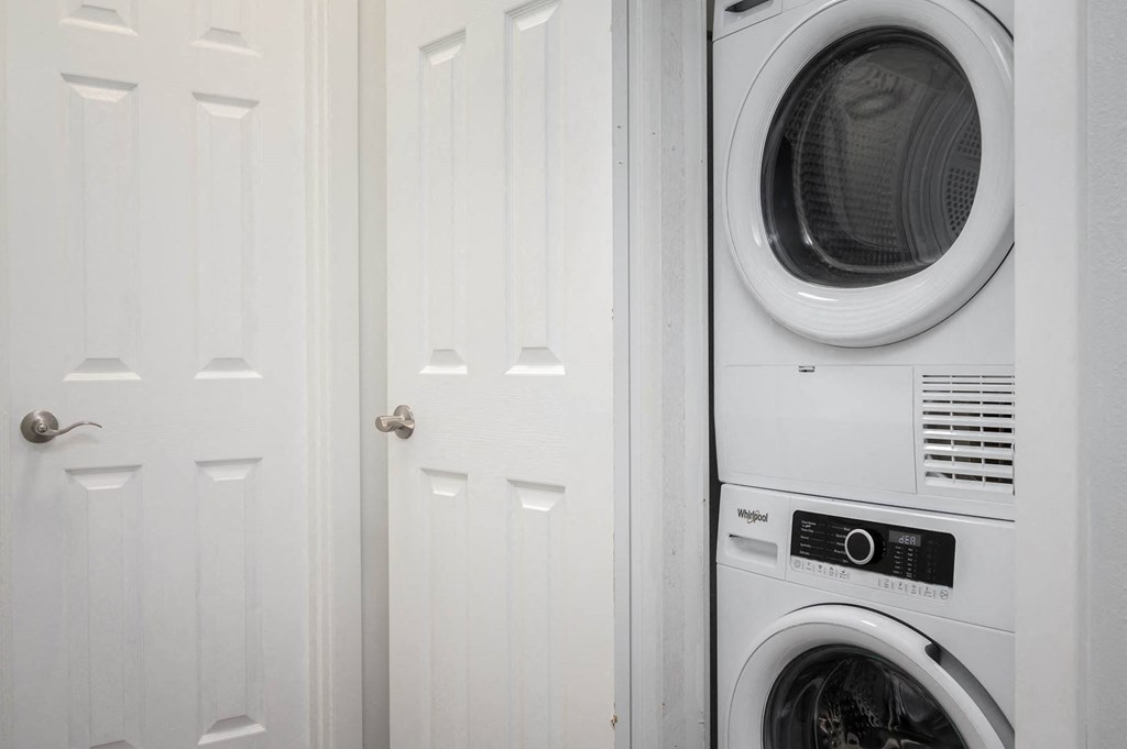 White washer and dryer in a white laundry room at The Ridge at Bellevue, Bellevue, WA