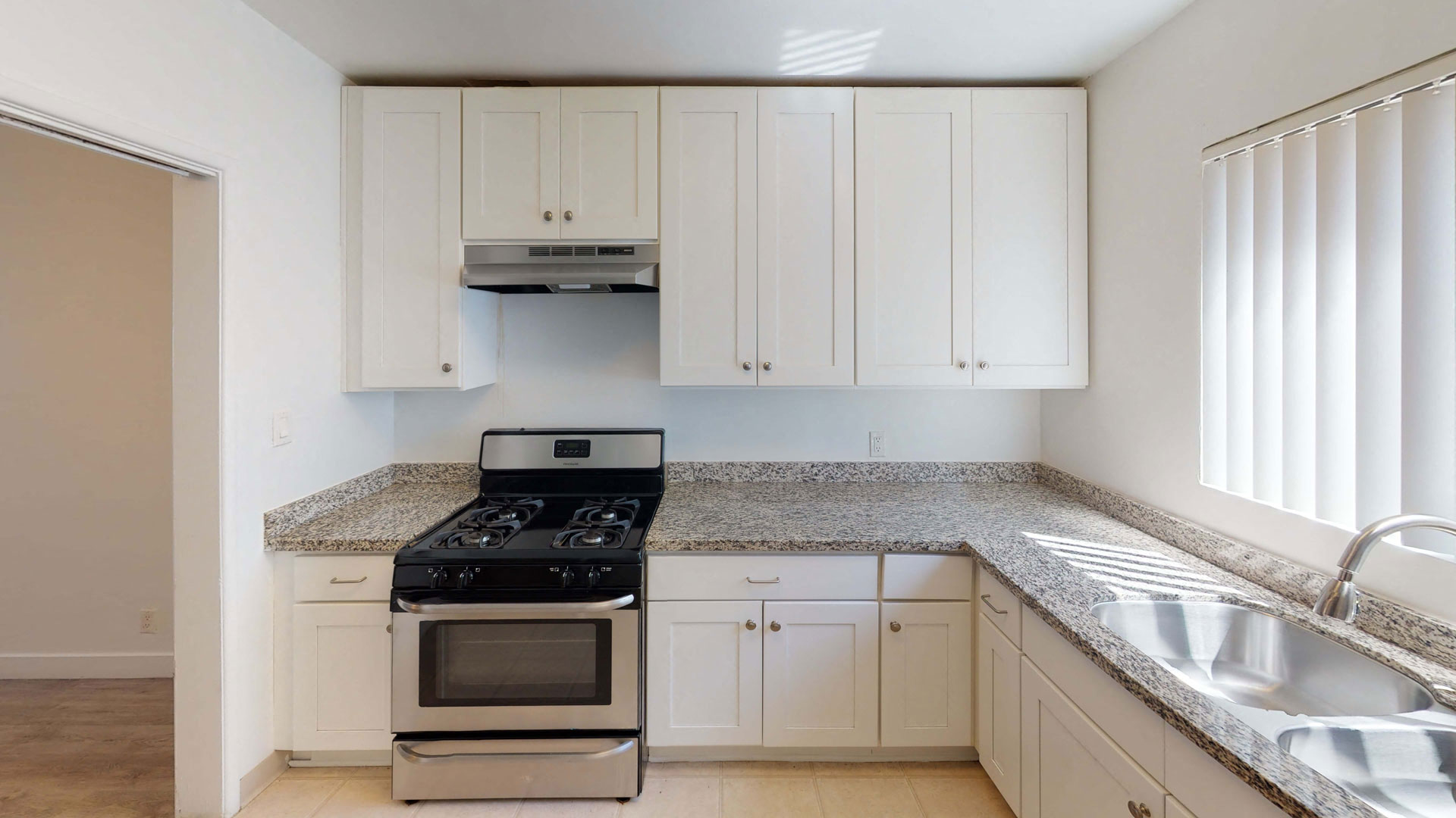 a kitchen with white cabinets and a stove and a sink