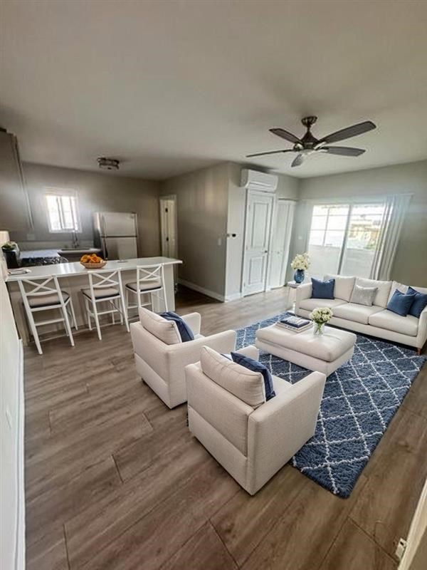 A living room with a white couch and a blue rug.