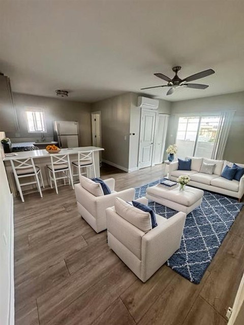A living room with a white couch and a blue rug.