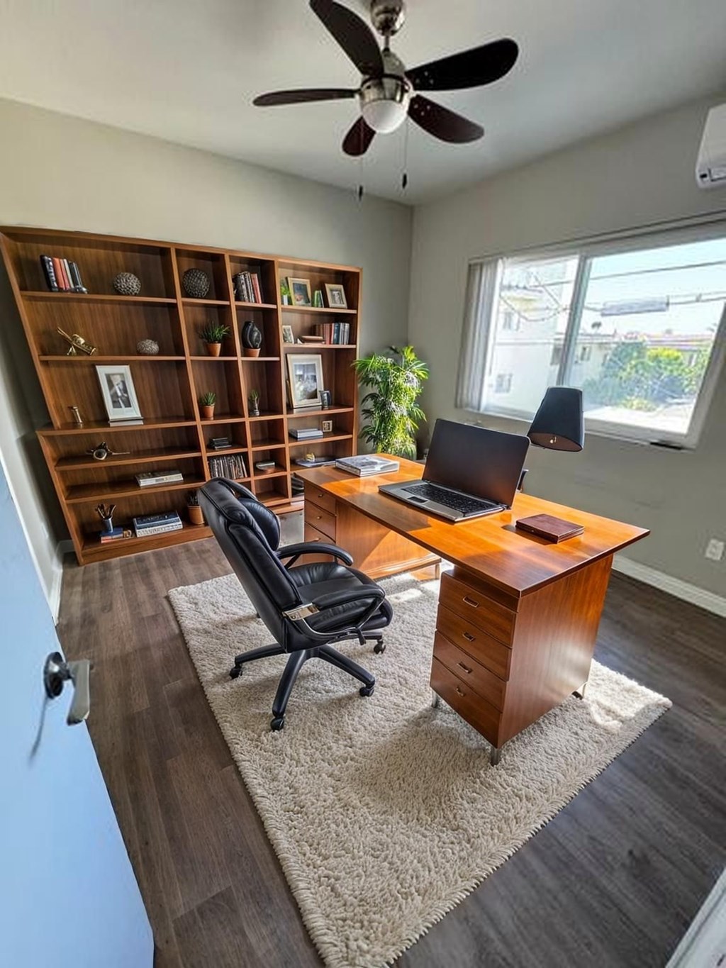 A room with a desk, chair, and bookshelf.
