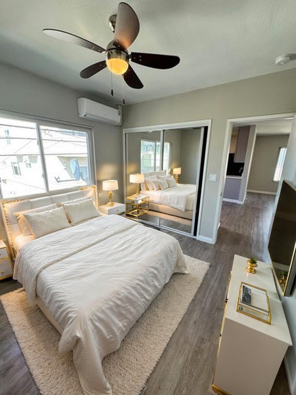 A bedroom with a large bed and a ceiling fan.