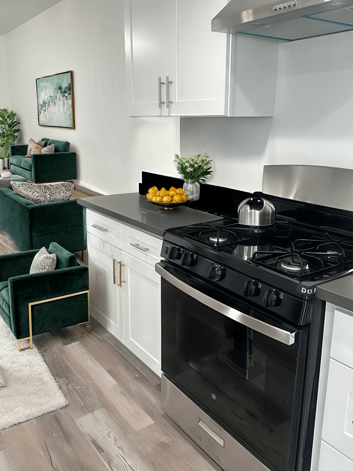 A modern kitchen with a black stove top oven and white cabinets.