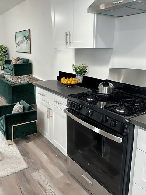 A modern kitchen with a black stove top oven and white cabinets.