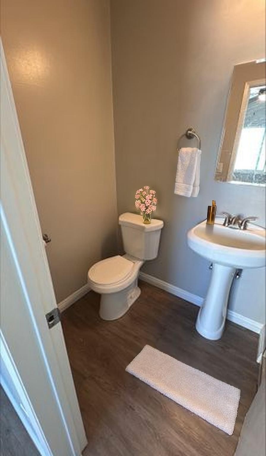 A small bathroom with a toilet, sink, and rug.