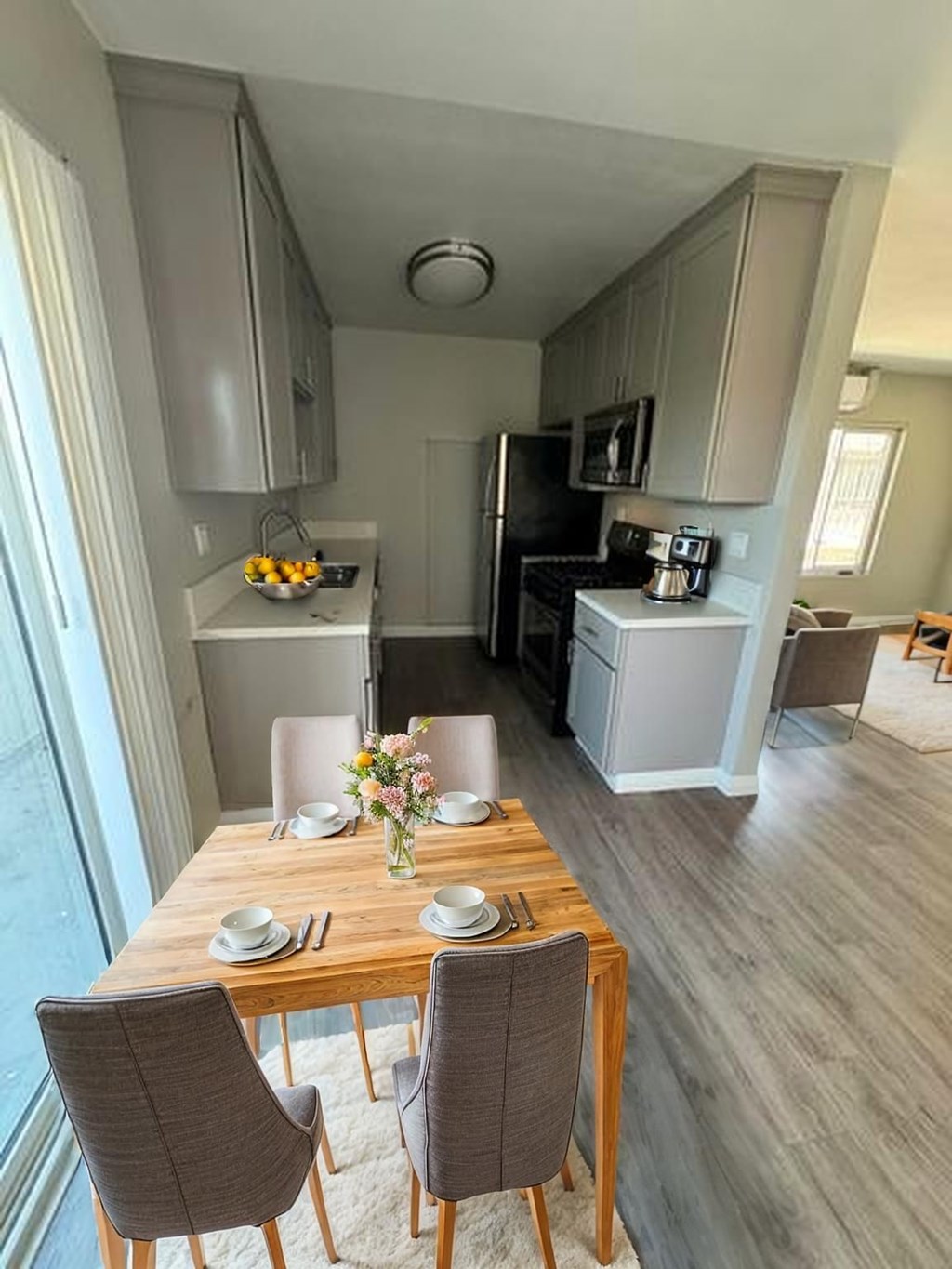 A modern kitchen with a dining table set for two.