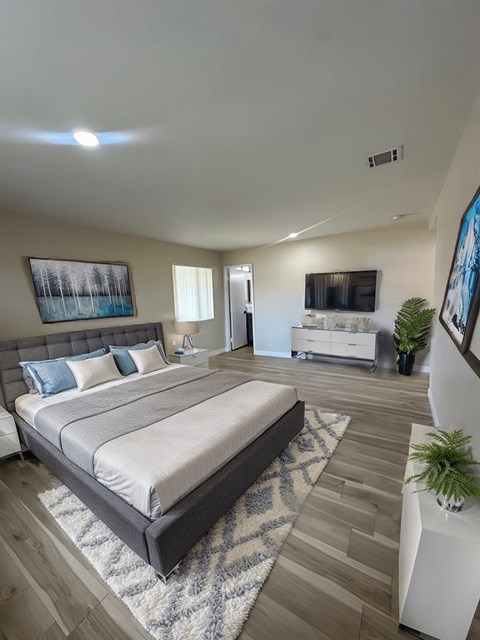 A bedroom with a large bed and a painting on the wall.