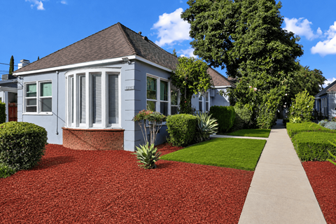 A house with a red gravel driveway and a concrete walkway.