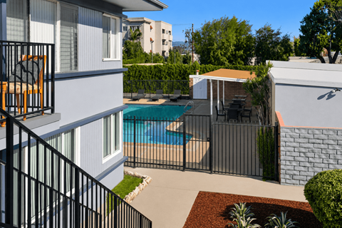 A small pool in a backyard surrounded by a black fence.