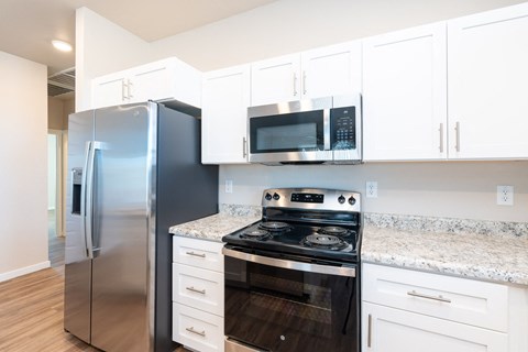 a kitchen with stainless steel appliances and white cabinets