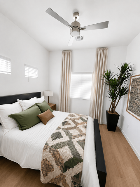 A bedroom with a bed, a ceiling fan, and a potted plant at The Villas at Riverwalk in Camp Verde, AZ, 86322