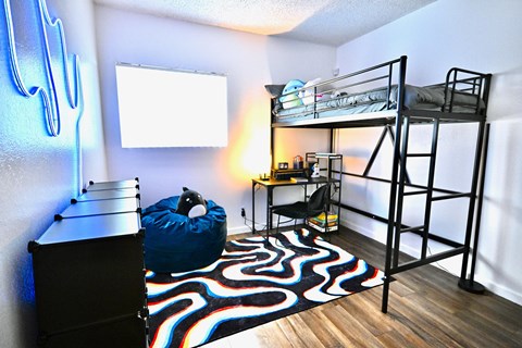 A room with a bunk bed and a bean bag chair.