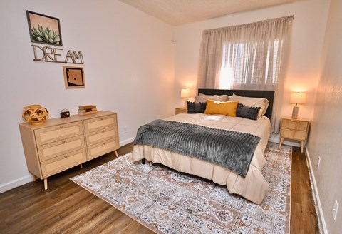 A bedroom with a bed, nightstands, and a rug.