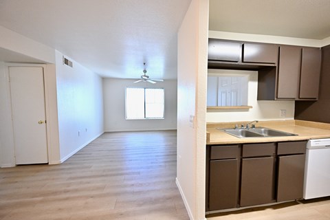 A kitchen with brown cabinets and a white dishwasher.