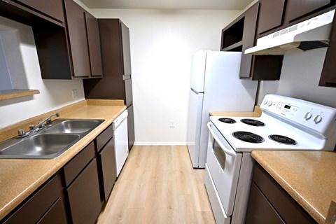 A kitchen with brown cabinets and a white stove.