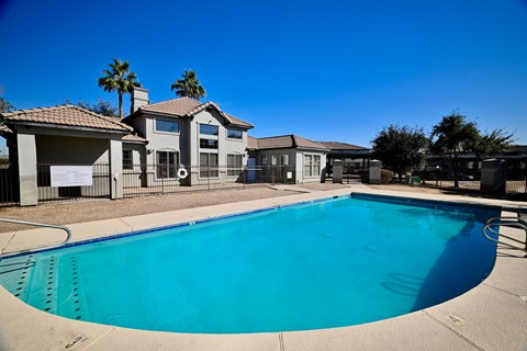 A swimming pool in front of a house.