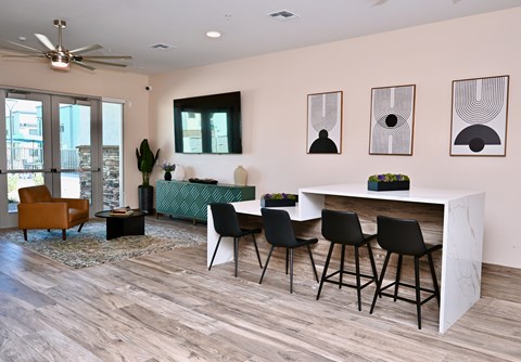 A living room with a white table and black chairs.