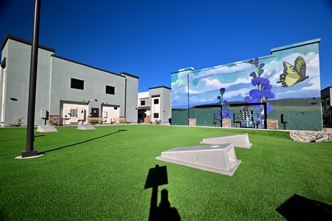 A person is holding a shadow of a person in front of a building.