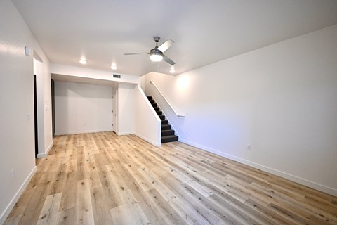 A room with wooden floors and a staircase.