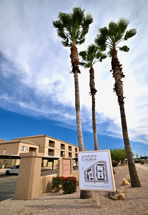 A sign for Ventana Estates is in front of a building and some trees.