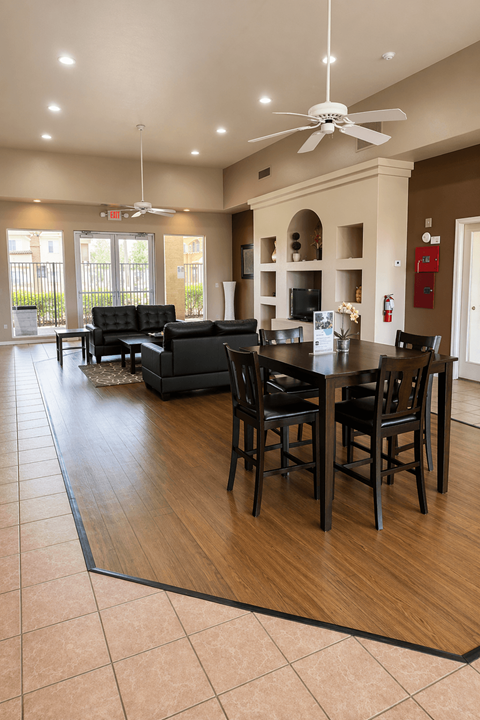 A modern living room with a black sofa set and a dining table with chairs.