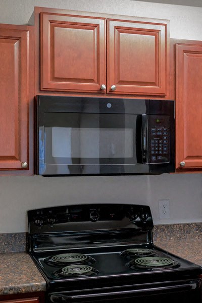 a black stove and a microwave in a kitchen
