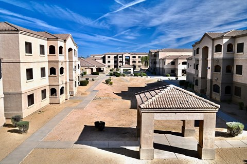 A courtyard surrounded by buildings with a clear blue sky above.