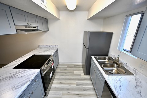 A kitchen with a black stove top oven and a black refrigerator.