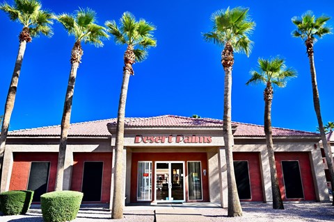 A building with a red roof and a sign that says DESERT PALMS