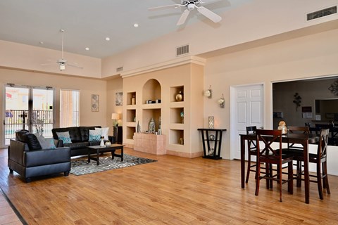 A living room with a black couch and a wooden floor.