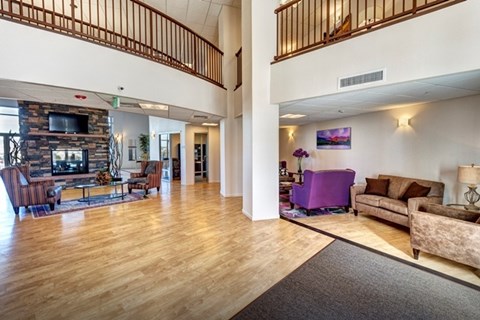 A living room with a purple couch and a fireplace.