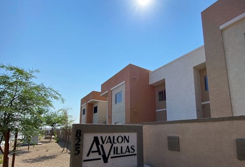 A building with a sign that says "AVALON VILLAS" in front of it.