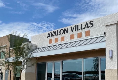 Avalon Villas building with a clear blue sky in the background.
